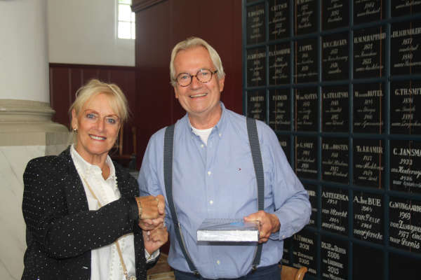 ©Makkumerbelboei. De tweeduizendste bezoeker Hanni Rinia ontvangt uit handen van Abe Blanksma het boek 