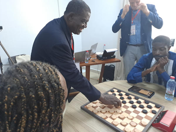 Foto WFD: Claude Ngodiep, voorzitter Kameroene Dambond, verricht de eerste zet van het African Open 2025